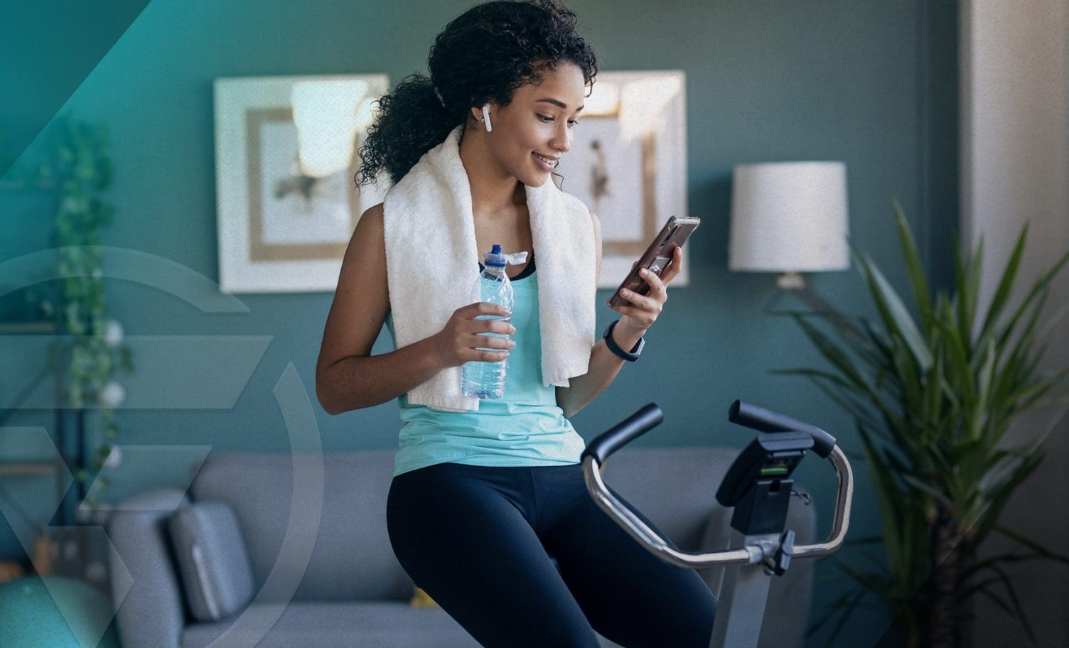 Woman checking her phone after finishing her stationary bike workout.